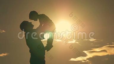 父亲和儿子在公园里玩耍，夕阳下，一个幸福的家庭剪影